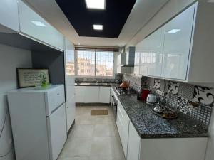 a kitchen with white cabinets and a white refrigerator at Luxueux appartement au centre de Rabat in Rabat