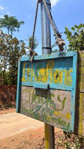 un panneau avec graffiti attaché à un poteau dans l'établissement Lily's Stone Garden, 