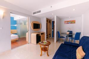 a living room with a blue couch and a table at Kuta Beach Hotel in Kuta