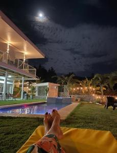 a person laying on a blanket by a pool at night at Casa Blanca de Chicá in Chicá