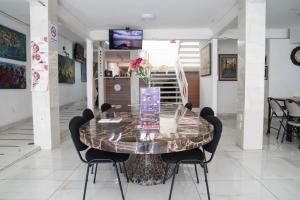 a dining room with a glass table and chairs at Hotel del Arte y Figura in León