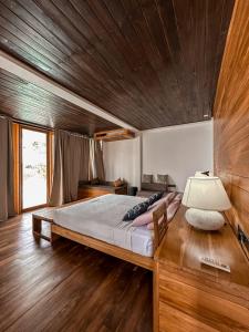 1 dormitorio con 1 cama grande y techo de madera en Giri Villa, en Tangalle