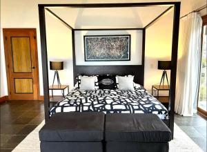 a bedroom with a black bed with a black canopy at VIP Terrenas Service in Santa Bárbara de Samaná