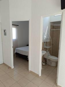 a bedroom with a bed and a toilet and a sink at Mini casa Ecoterra Santa Ana in Santa Ana