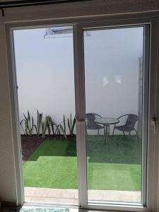 a sliding glass door with a patio with a table and chairs at Mini casa Ecoterra Santa Ana in Santa Ana
