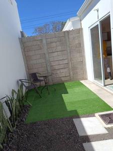 a patio with a table and chairs and a brick wall at Mini casa Ecoterra Santa Ana in Santa Ana