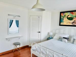 バンコクにあるSamanchan Sukhumvit 42の白いベッドルーム(白いベッド1台、窓付)