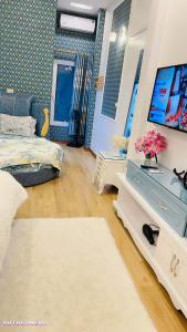 uma sala de estar com uma cama e uma televisão em Luxury Hotel T&L em Cẩm Phả