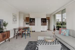 uma sala de estar com um sofá e uma mesa em Peaceful 1-Bed Apartment Close to Lonsdale St em Camberra