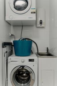 uma máquina de lavar roupa com um cesto azul em cima em Peaceful 1-Bed Apartment Close to Lonsdale St em Camberra