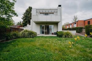 a white house with a green yard at Peaceful 1-Bed Apartment Close to Lonsdale St in Canberra +19 photos