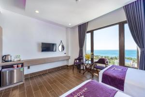 una camera con letto e balcone con vista sull'oceano di Maison Hotel PQ - by BAY LUXURY a Phu Quoc