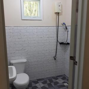 łazienka z białą toaletą i oknem w obiekcie Whitesands Beach Resort w mieście San Isidro