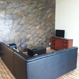 salon z kanapą i kamienną ścianą w obiekcie Whitesands Beach Resort w mieście San Isidro