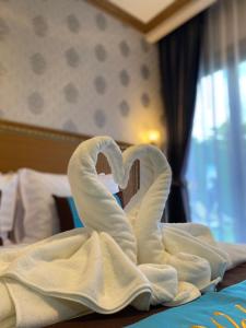 una escultura de toallas de cisnes sentados en una cama en Baan Plaifah Khao Yai Hotel en Khao Yai