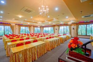 einen Bankettsaal mit Tischen, Stühlen und einem Kronleuchter in der Unterkunft Baan Plaifah Khao Yai Hotel in Khao Yai