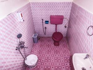 a pink bathroom with a toilet and a sink at Heaven Bungalow in Ooty