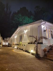 a white house with lights on the side of it at Heaven Bungalow in Ooty