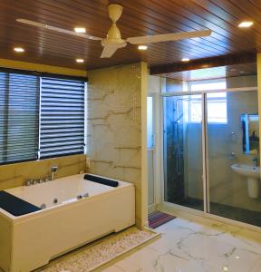 ein großes Bad mit einer Badewanne und einem Waschbecken in der Unterkunft Grand Rovinka Hotel in Dehiwala