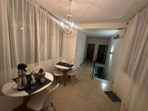 a dining room with a table and chairs and a chandelier at Hostal Vicente in Salta