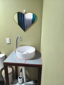 卡維塔的住宿－Villalu.，一间带水槽和心形镜子的浴室