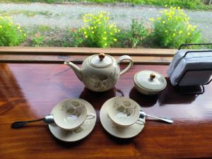a tea set on a table with two cups and spoons at Villalu. in Cahuita +26 photos