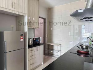 a kitchen with a refrigerator and a counter top at 3BR 5-6Pax Zetapark Setapak Central, Lake View in Kuala Lumpur