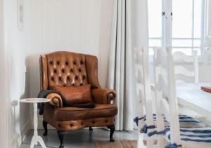 a brown chair sitting in a room with a table at Sunday at Mirumiru with Views, Space and Serenity in Tenterfield