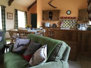 a living room with a couch and a kitchen at Swallows’ Barn in Durham