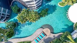 vista sul tetto di una piscina con palme di Le Meridien Bali Jimbaran a Jimbaran