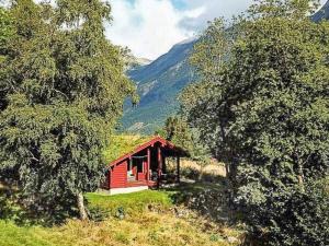 uma pequena cabana vermelha no meio de uma montanha em 6 person holiday home in olden em Olden