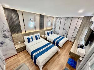 a bedroom with two beds and a tv at Eden Hotel in Ho Chi Minh City