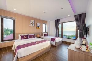 a hotel room with two beds and large windows at Maison Hotel PQ - by BAY LUXURY in Phu Quoc +42 photos