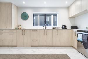 eine Küche mit Holzschränken und einem Fenster in der Unterkunft Style meets comfort 2 Bed CHCH CBD in Christchurch
