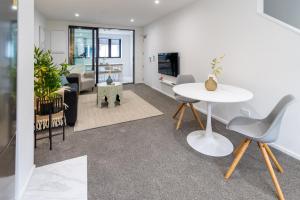ein Wohnzimmer mit einem weißen Tisch und Stühlen in der Unterkunft Style meets comfort 2 Bed CHCH CBD in Christchurch