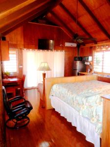 a bedroom with a bed and a desk and a chair at Sigasiga Sands Boutique Bungalows in Savusavu