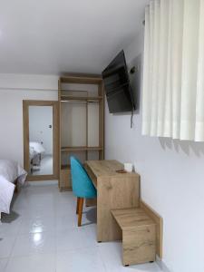 Habitación con 1 dormitorio y escritorio con silla azul. en PERLASCHALLAY en Ayacucho