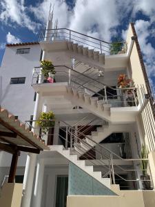 un edificio blanco con escaleras y macetas. en PERLASCHALLAY en Ayacucho