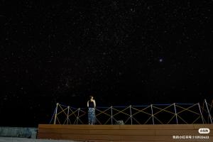 un hombre de pie en la parte superior de una valla por la noche en Jelly Sea Resort, en Siquijor