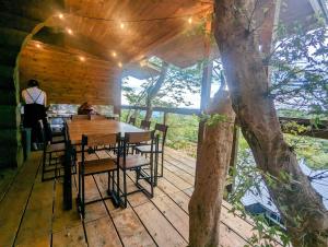 a wooden table and chairs on a deck with a tree at Renesto aHOLIDAYHOME - Vacation STAY 28000v in Kobe