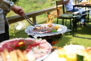 człowiek gotuje jedzenie na grillu w obiekcie Renesto aHOLIDAYHOME - Vacation STAY 28000v w mieście Kobe