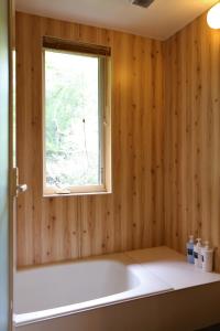 a bathroom with a window and a white tub at Renesto aHOLIDAYHOME - Vacation STAY 27984v in Kobe