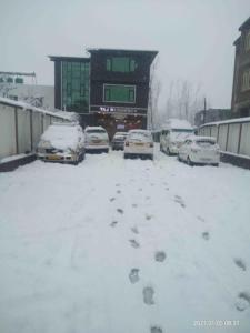 a parking lot with cars covered in snow at Hotel Taj Residency Srinagar in Srinagar