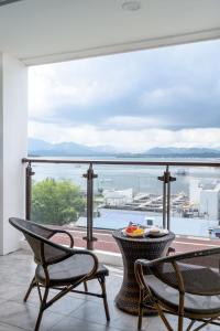 einen Balkon mit einem Tisch und Stühlen sowie Blick auf das Wasser in der Unterkunft Sunlight Guest Hotel in Puerto Princesa