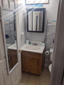 a bathroom with a sink and a mirror and a toilet at Beach Haven w/Spacious Balcony in Hampton