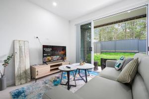 a living room with a couch and a tv at Rousehill 5Br with Pool near Shopping Centre&Train in Riverstone