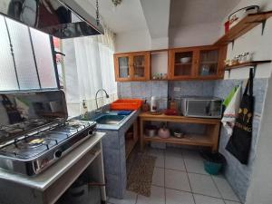 a small kitchen with a stove and a sink at Departamento Las Malvinas Puno in Puno