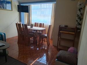 a dining room with a table and chairs and a window at Departamento Las Malvinas Puno in Puno