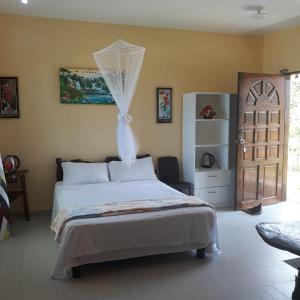 a bedroom with a bed with a mosquito net at Whitesands Beach Resort in San Isidro