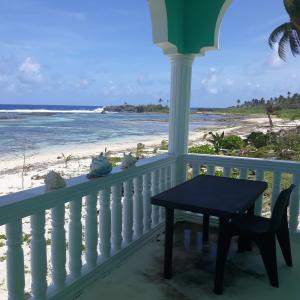 balkon ze stołem i widokiem na plażę w obiekcie Whitesands Beach Resort w mieście San Isidro